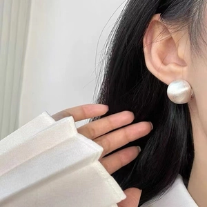 Minimalist brushed silver ball stud earrings featuring a large matte metal sphere design