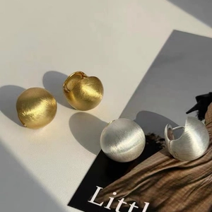 Matte gold and silver brushed metal semi-ball stud earrings with elegant long shadows