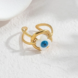 Detail of gold evil eye ring with white floral element and adjustable double-band design