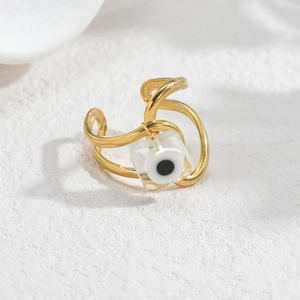 Macro shot of gold wave-textured adjustable ring with a square evil eye charm pendant