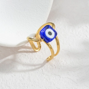 Macro shot of French vintage open ring with a blue square eye charm and double gold bands