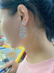 Silver long ginkgo leaf dangle earrings with hammered texture on model