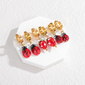 Three pairs of vintage gold hoop earrings with strawberry and ladybug glass charms
