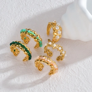 Lot de cinq boucles d'oreilles 18K plaqué or avec perles colorées sur fond de marbre