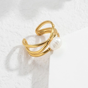 Detail of interlocking gold titanium ring band featuring a round white pearl inlay