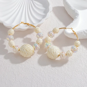 Boucles d'oreilles créoles tressées avec perles irisées sur une base au fini doré