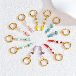 Flat lay of colorful starfish and coral drop earrings with pearls and gold hoops