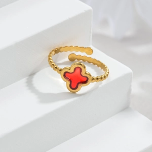 Detail eines verstellbaren 18k Goldrings mit rotem Kleeblatt und Perlenstruktur