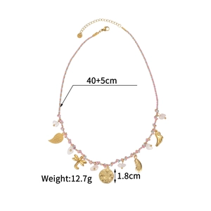 Detail of woven ocean style necklace with 18k gold pendants including moon and dragonfly