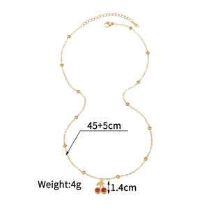 Détail du collier pendentif cerise dorée avec cristaux rouges et chaîne en acier perlé