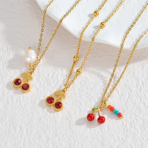 Colliers dorés avec pendentifs cerises en strass rouges et détails de perles colorées