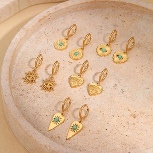 Detail view of 5 pairs of gold evil eye heart earrings with synthetic turquoise inlay