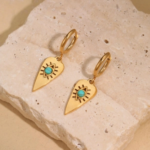 Gold stainless steel evil eye drop earrings with turquoise bead on beige stone