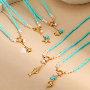 Close-up of bohemian blue beaded necklaces with golden sea star and turtle pendants