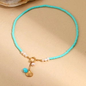 Detail of bohemian ocean necklace with blue clay beads, pearls and golden shell pendant