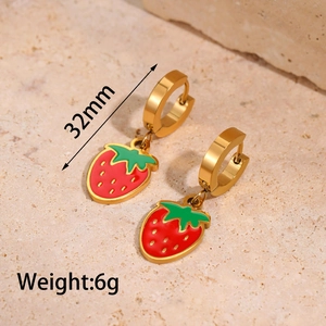 Close-up of 32mm red enamel strawberry drop earrings with golden hoops and 6g weight
