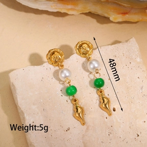 Detailed view of 48mm gold rose and seashell drop earrings with pearl and green beads