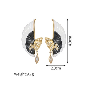 Detail view of gold-plated wing earrings with black enamel and dimensions of 4.9cm by 2.3cm
