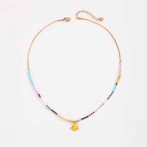 Colorful beaded necklace with yellow fish pendant and gold chain on white background