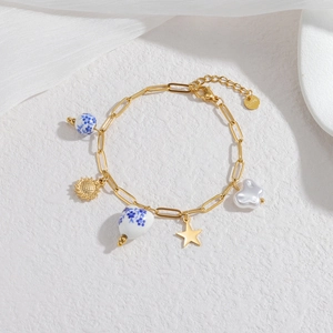 Elegant gold chain bracelet with ocean-themed ceramic beads and mixed star pendants