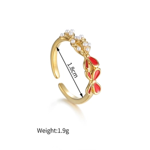 Detail of adjustable golden bow ring with red enamel and small white pearls, weight 1.9g