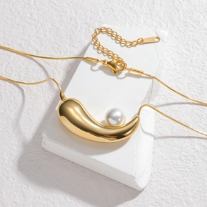 Minimalist gold stainless steel necklace featuring a curved pendant and a round pearl