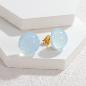 Light blue resin ball stud earrings with gold S925 posts on a white display stand