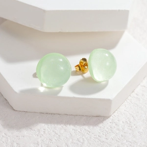 Sweet light green translucent sphere stud earrings with subtle shimmer on white stand