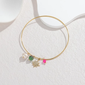 18K gold plated stainless steel bracelet with star, pearl and crystal charms on white stone