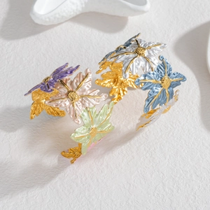 Detail of golden flower bangle with colorful enamel petals and intricate floral textures