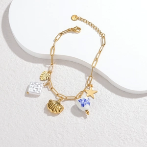 Gold stainless steel charm bracelet with shell, star, and blue floral heart pendants