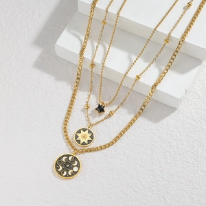 Three-layer vintage gold necklace featuring star and moon pendants on a display stand