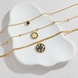 Retro multi-layer gold necklace set with star and moon phase charms on white tray
