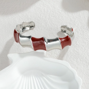 Modern wavy open bangle with red enamel segments on polished stainless steel base