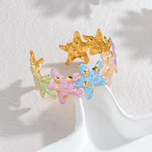 Golden open bangle bracelet with colorful enamel star charms in ocean holiday style