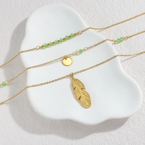 Collana a strati bohémien dorata con ciondoli a piuma e perle turchesi verdi