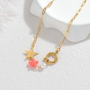 Golden ocean necklace featuring pink starfish, star pendant and white bead on white stone