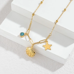 Gold necklace with shell flower and pearl pendants on elegant white stone blocks