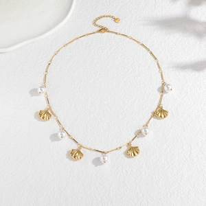 Golden stainless steel shell and pearl necklace with S-Steel tag on white background