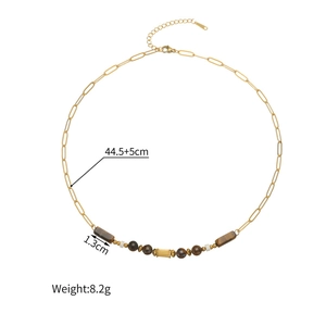 Détail d'un collier vintage perlé avec pierre œil de tigre brun et maillons dorés