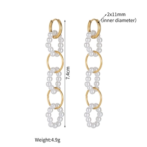Detailed view of 7.4cm long drop earrings with gold rings and white pearls