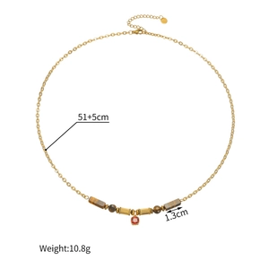 Detail of 18k gold sweater chain with brown beads, ruby pendant and size dimensions