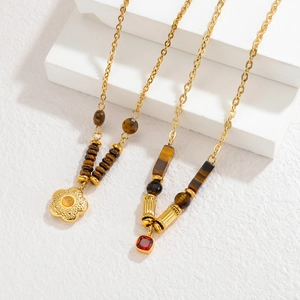 18k gold petal necklace with tiger eye stone beads on a minimalist white texture background