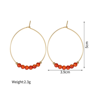 Vue détaillée des créoles dorées de 5cm avec six perles orange et un poids de 2,3g