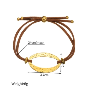 Detailed macro view of 18k gold geometric charm on brown cord adjustable bracelet
