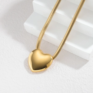 Collier minimaliste avec pendentif cœur en or 18k et chaîne serpent sur pierre blanche