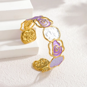 Golden flower bangle with purple enamel inlays on a geometric display stand
