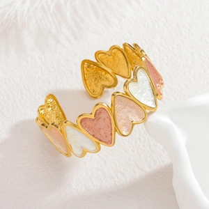 Gros plan détaillé des bracelets cœurs plaqués or 18k avec émail coloré sur socle blanc