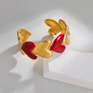 Modern gold-plated open bangle featuring textured hearts and red enamel heart charms