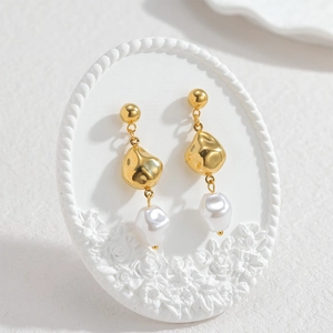18k gold-plated stainless steel earrings with baroque pearls on white floral stand